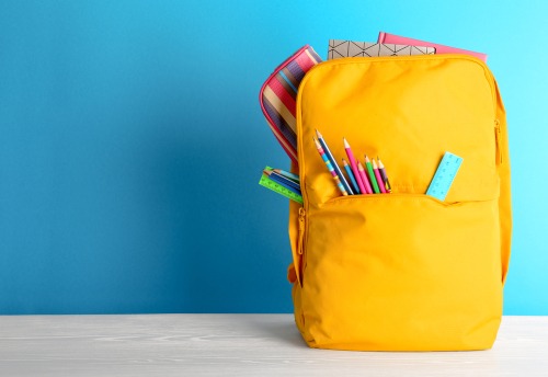Yellow backpack with pencils sticking out of it