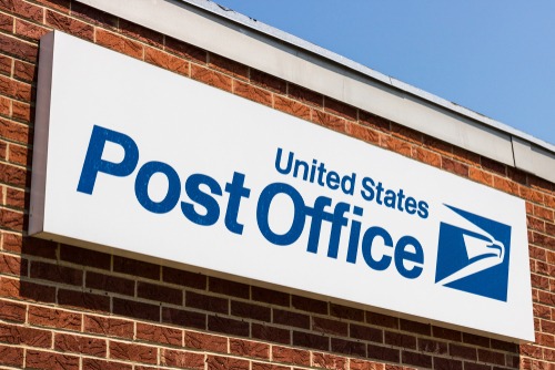 post office sign on a brick building